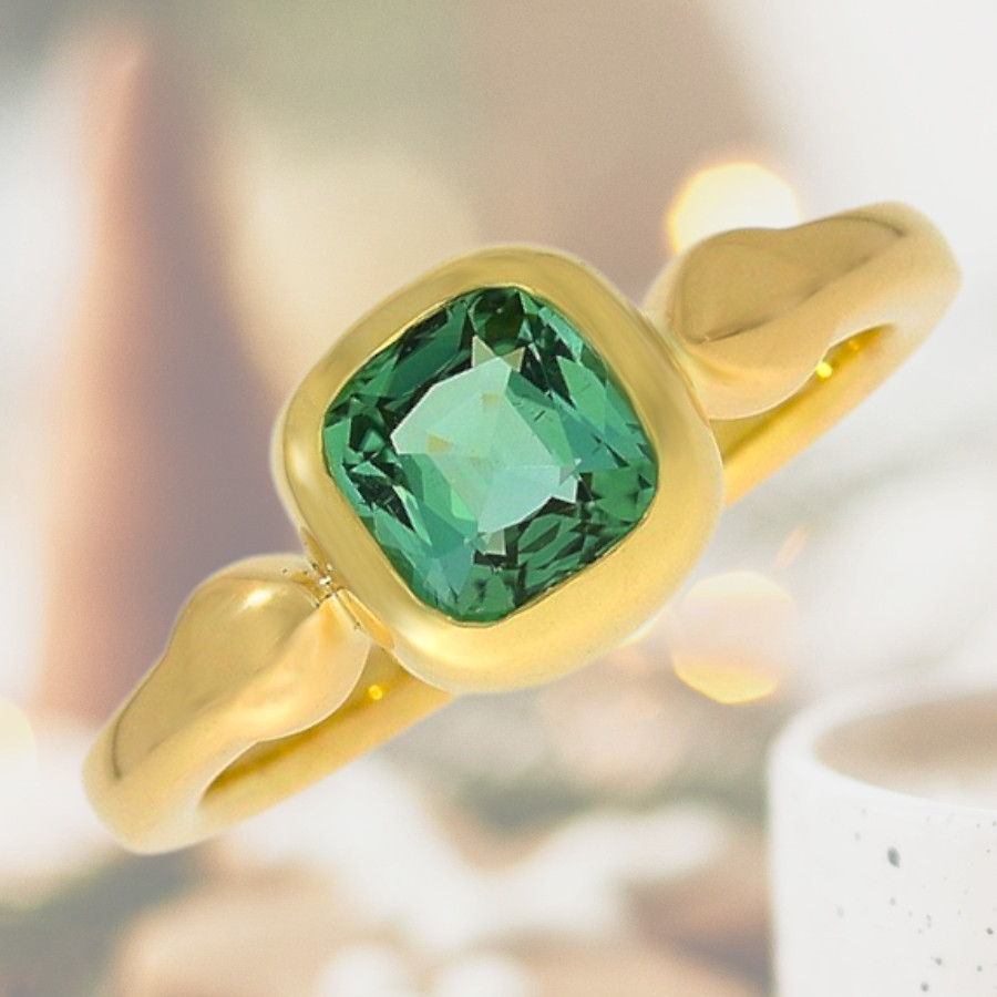 Ring mit fließender Form mit einem feinen mintgrünen Turmalin gefasst in 750er Gelbgold